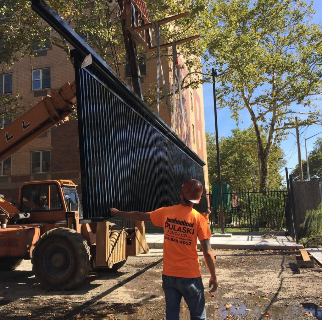 machine moving large aluminum vehicle gate into position