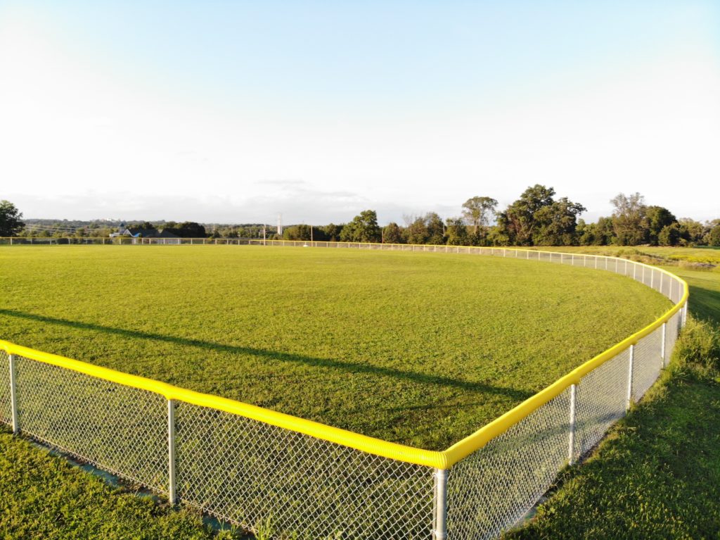 baseball field fence, chainlink fence with safety guard along the top.