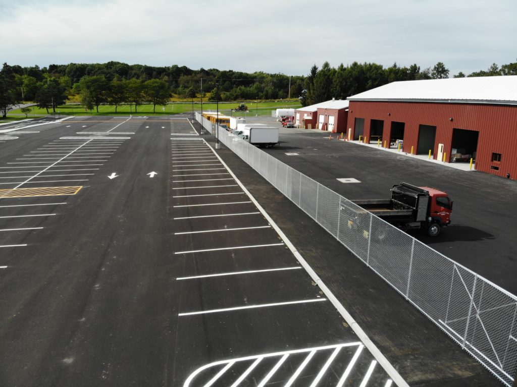 Photo of a chainlink fence in front of a school bus garage